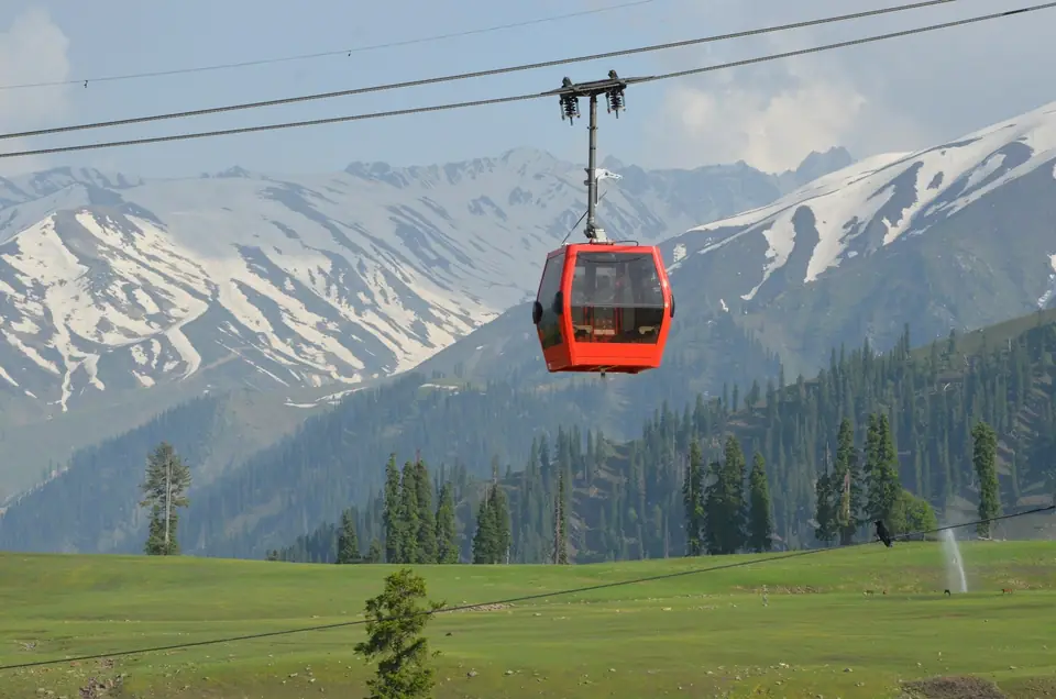 A red gondola cabin rising over the Gulmarg meadows A red gondola cabin rising over the Gulmarg meadows
