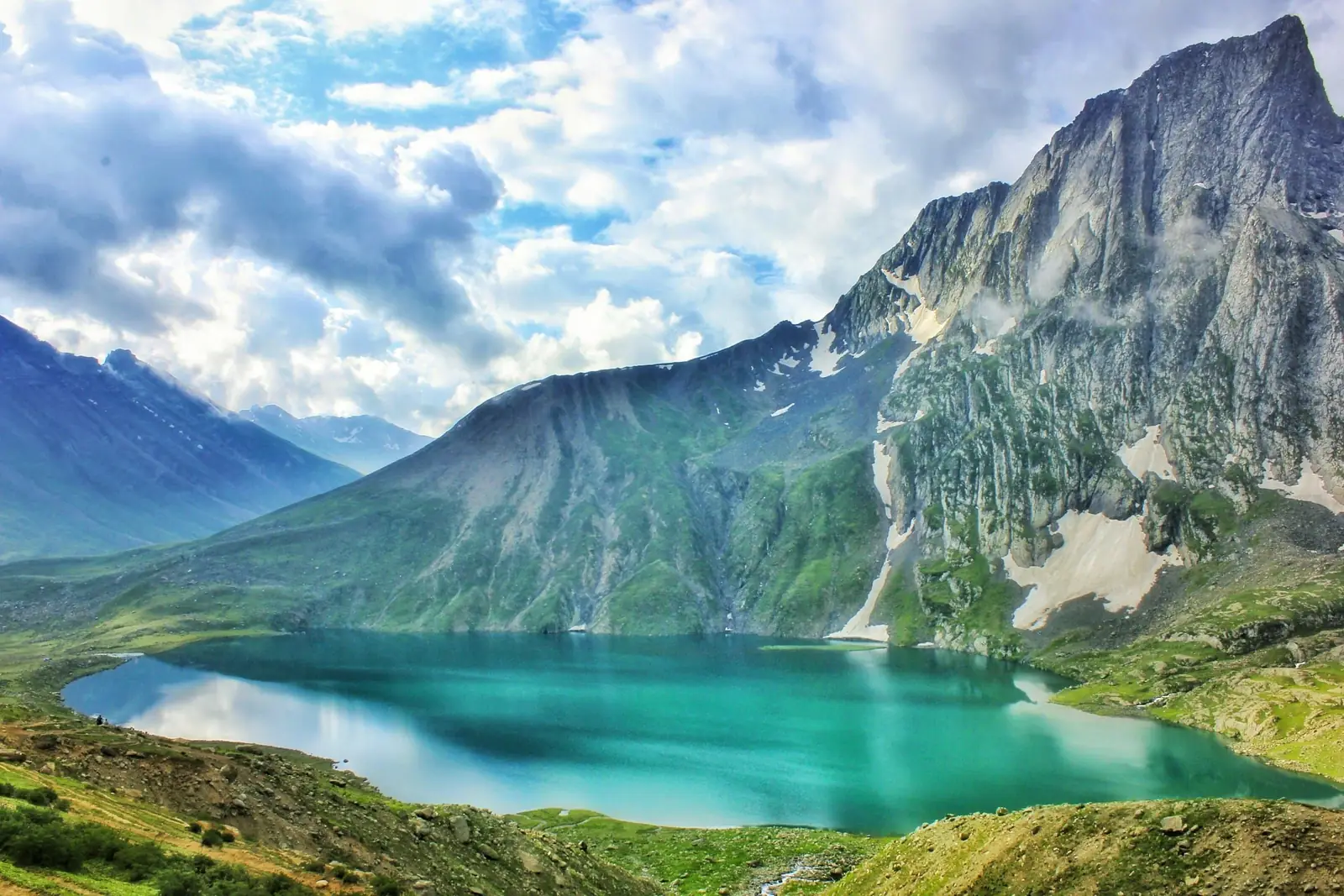 Turquoise alpine lake below cloud-wrapped Himalayan peaks in Kashmir Turquoise alpine lake below cloud-wrapped Himalayan peaks in Kashmir